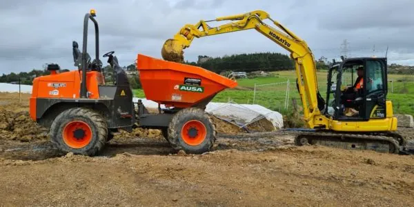 Yellow digger and orange loader on job site