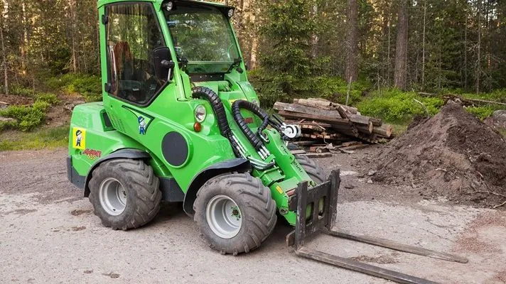 Avant loader parked by a forest